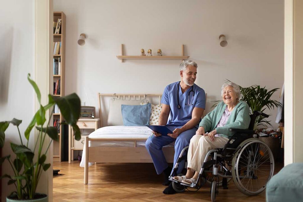 Older adults share a meal and conversation in a bright assisted living dining room.